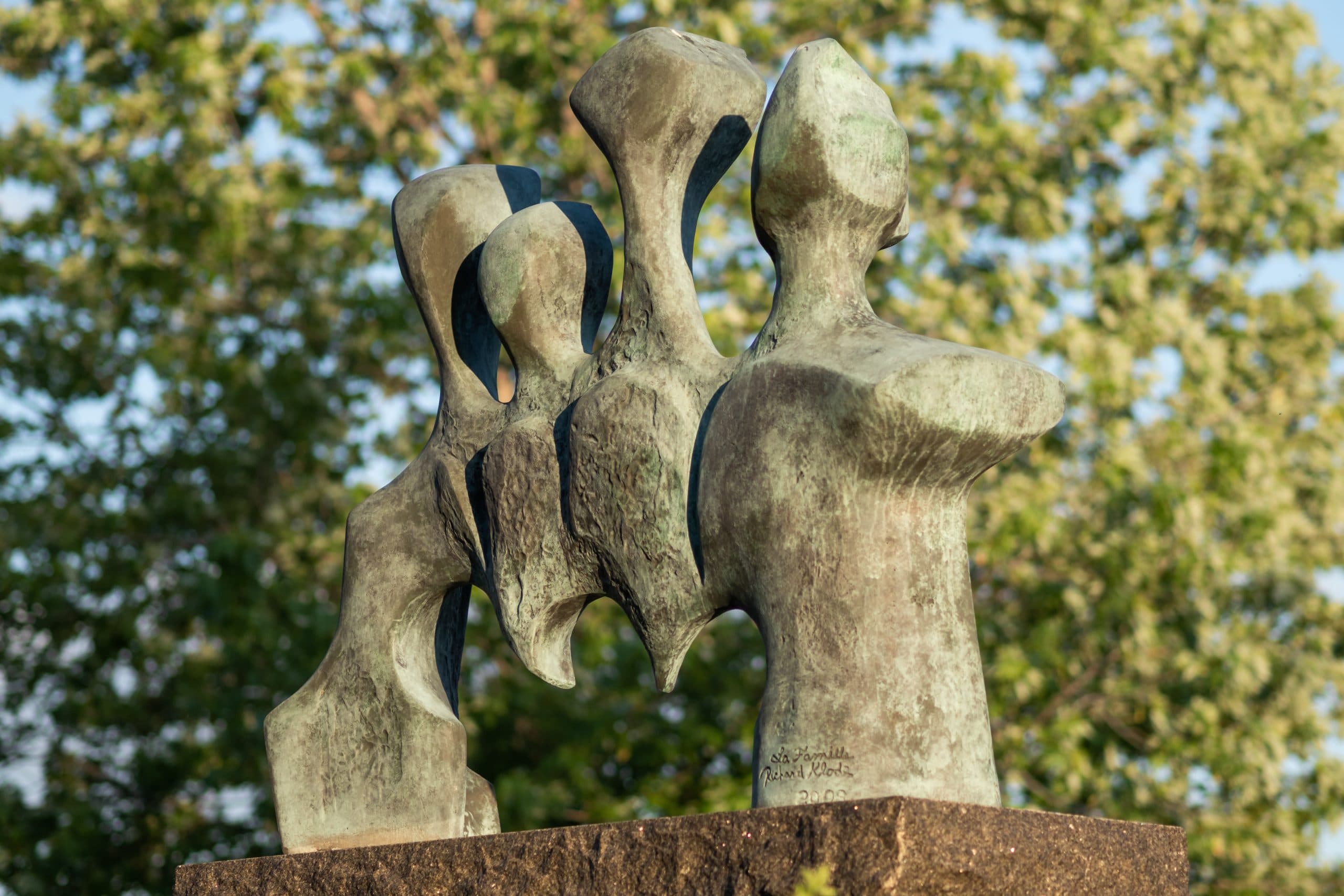 Catalogue d'art public - Richard Klode : La famille, sculpture de bronze représentant 4 personnes vivant les uns les autres au quotidien.