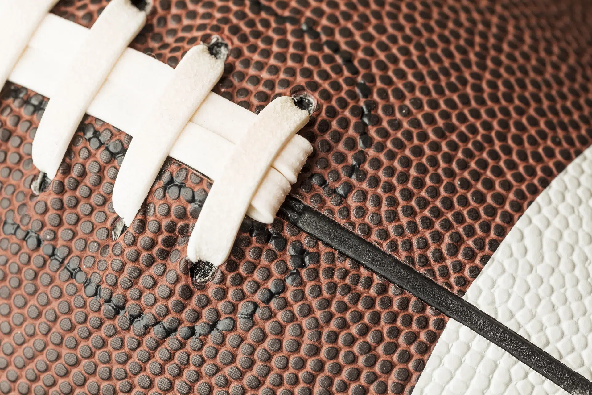 vue de proche des coutures d'un ballon de touch-football