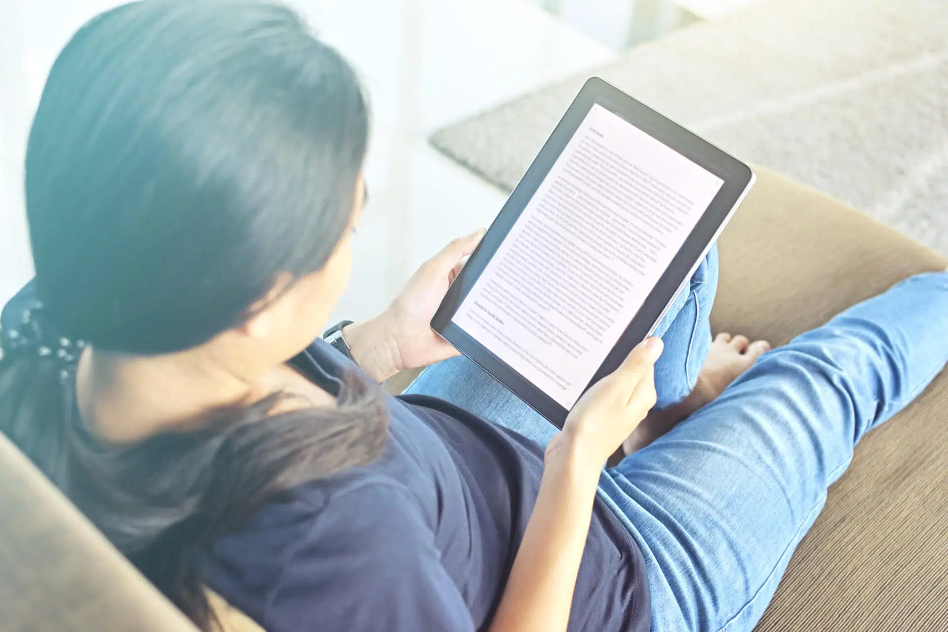 Une dame qui lit sur une tablette numérique
