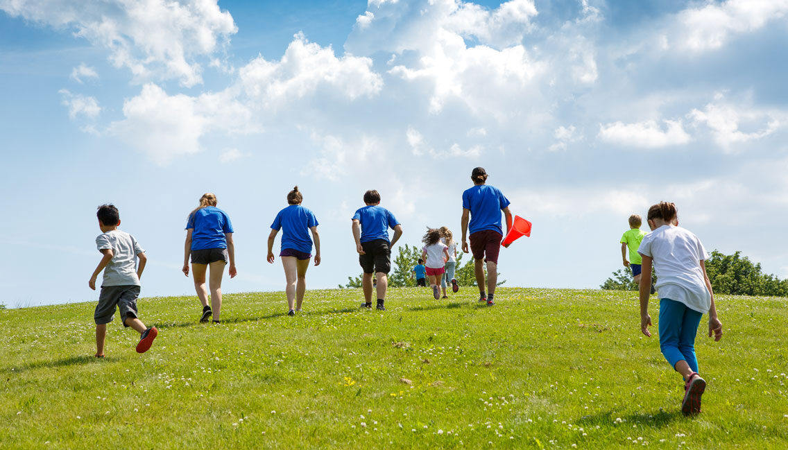 Quatre moniteurs et des jeunes montent une colline