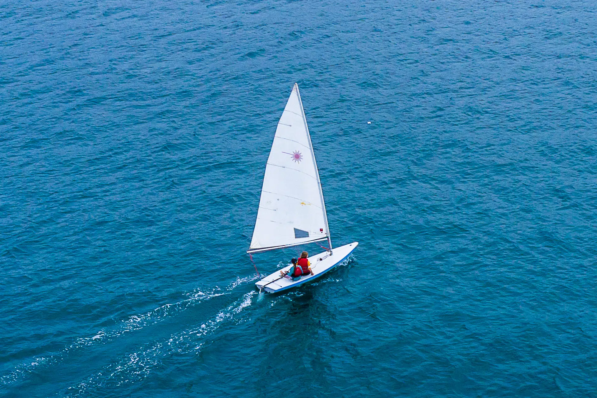 Barreur et un coéquipier dans son voilier sur l'eau