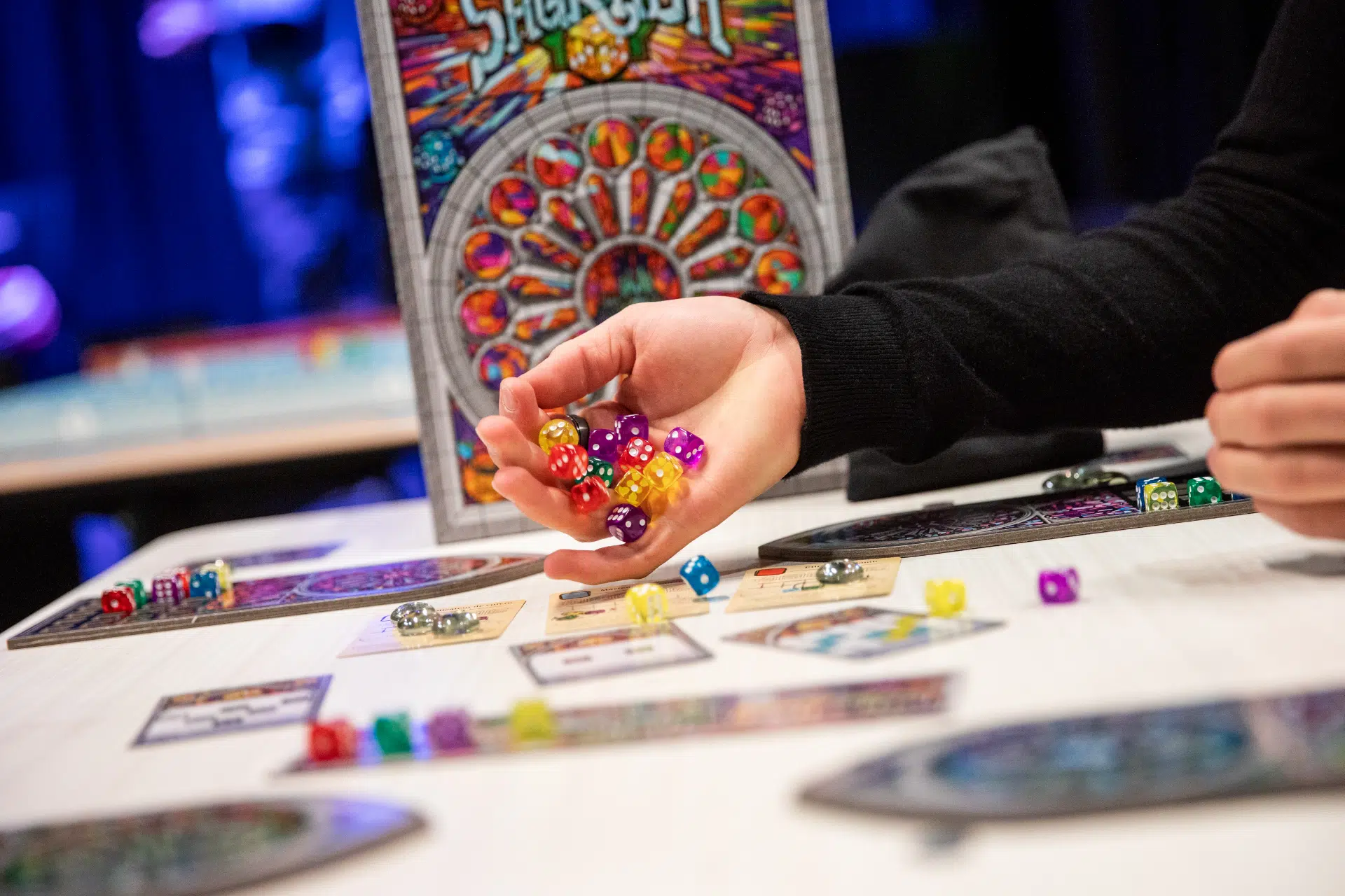 Main tenant plusieurs dés au-dessus d'une planche de jeux