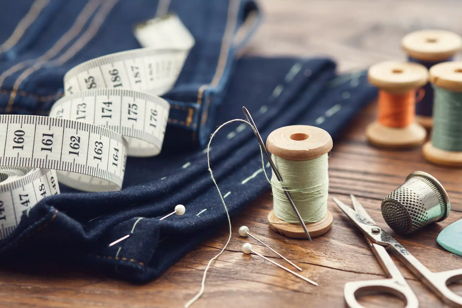 Ruban à mesurer, tissu, bobines de fil et ciseaux de couture