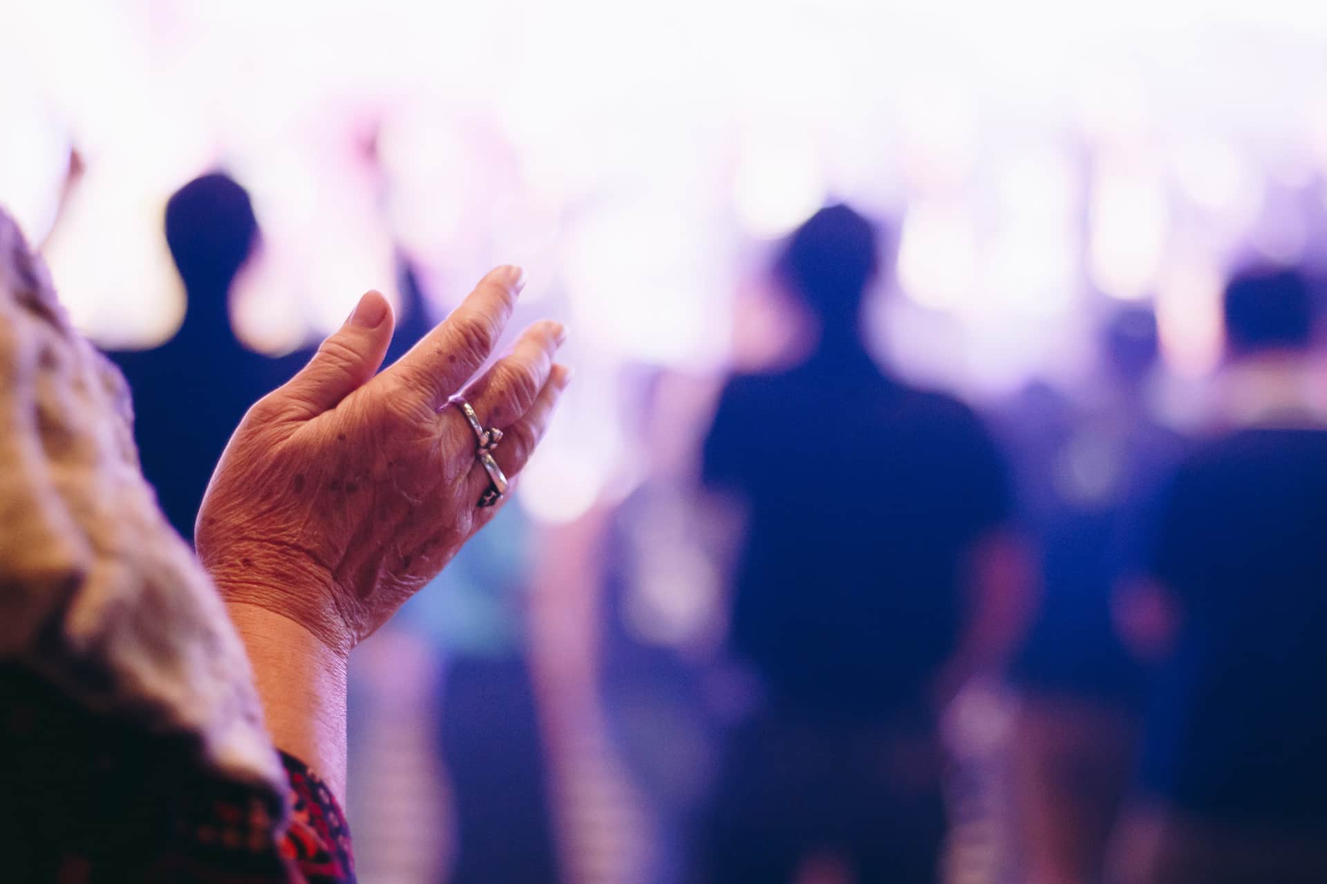 Dame aînée qui applaudie dans une foule devant un spectacle