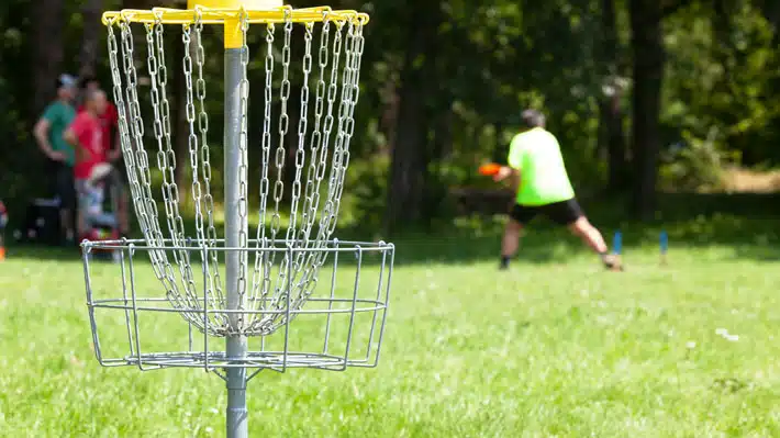 Hommes jouant au disque-golf à l'extérieur