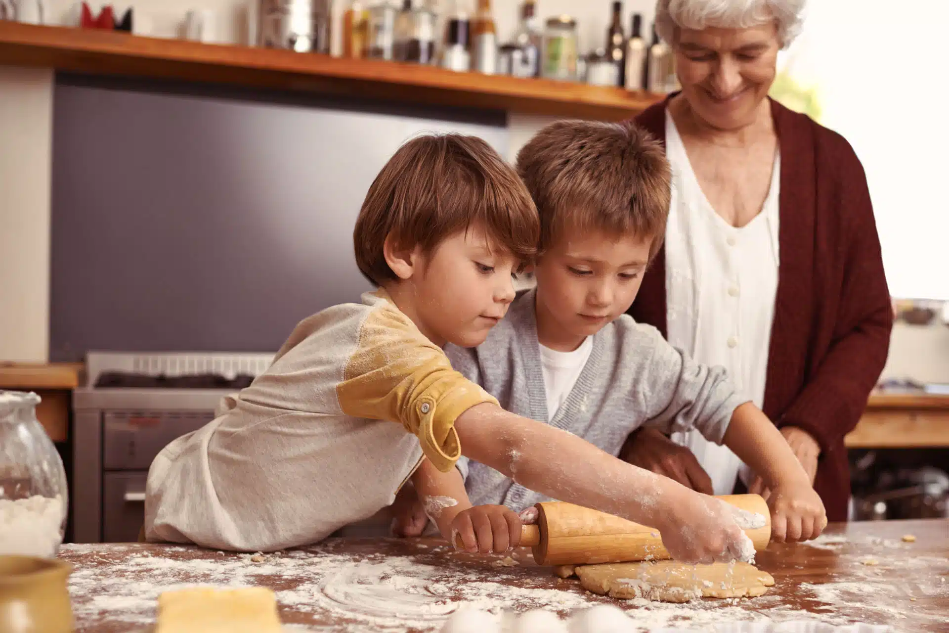 deux petits garçons font la cuisine avec leur grand-maman
