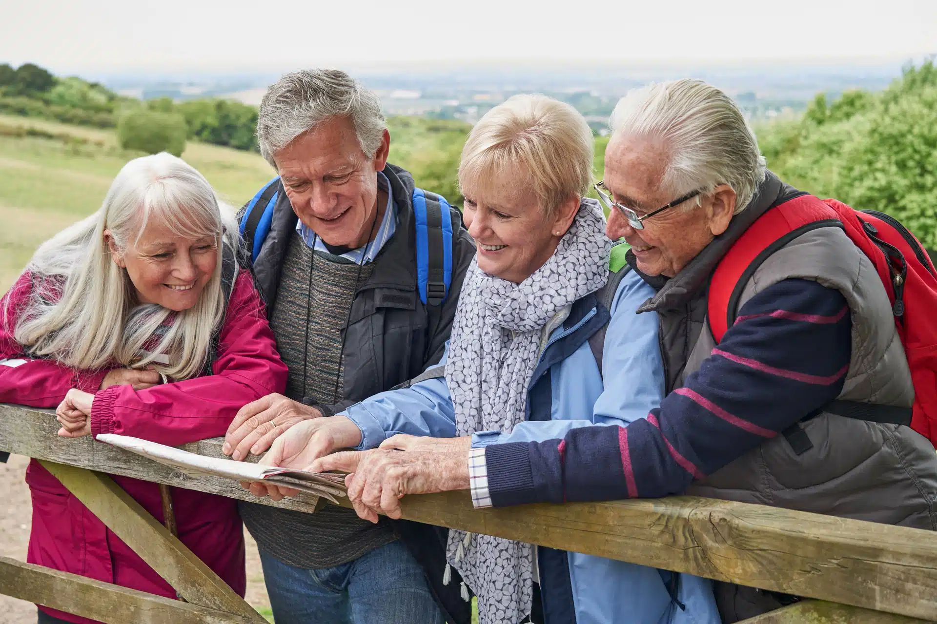 Quatre personnes aînées regardent une carte de sentier