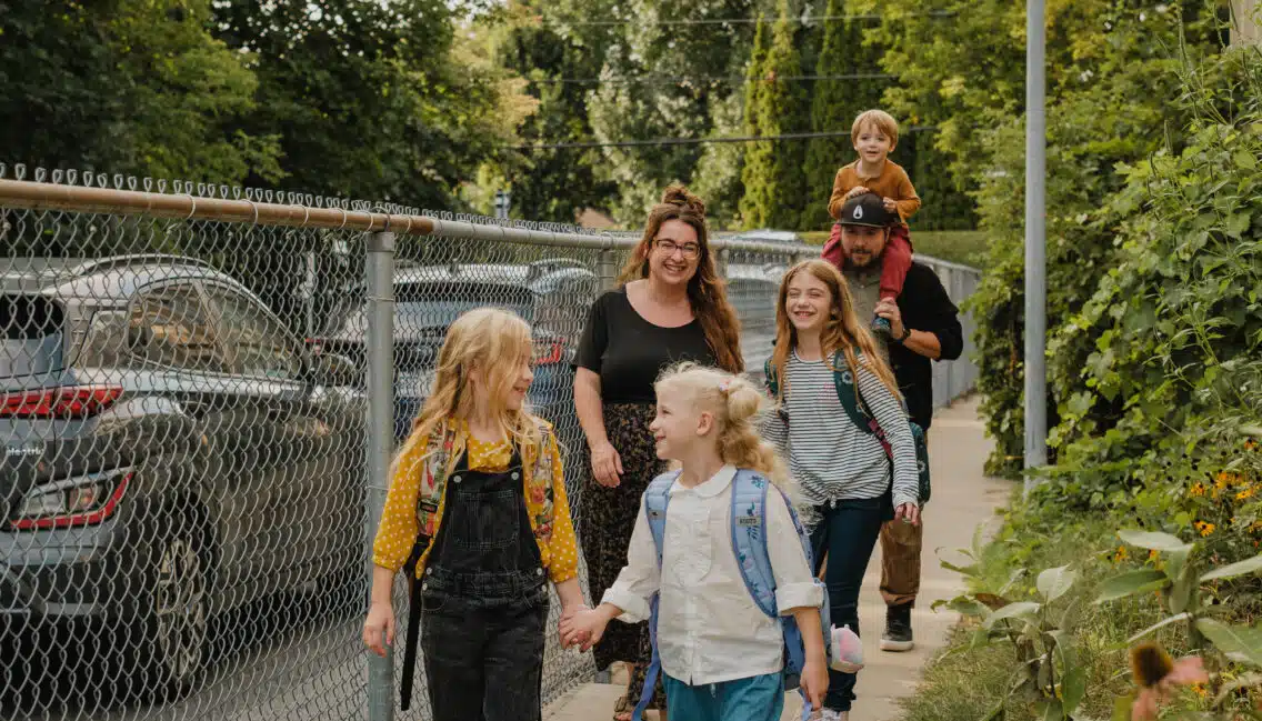 Famille avec 3 enfants qui marche près d'une école