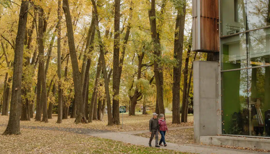 Couple de personnes âgées qui se promène dans le boisé de la bibliothèque