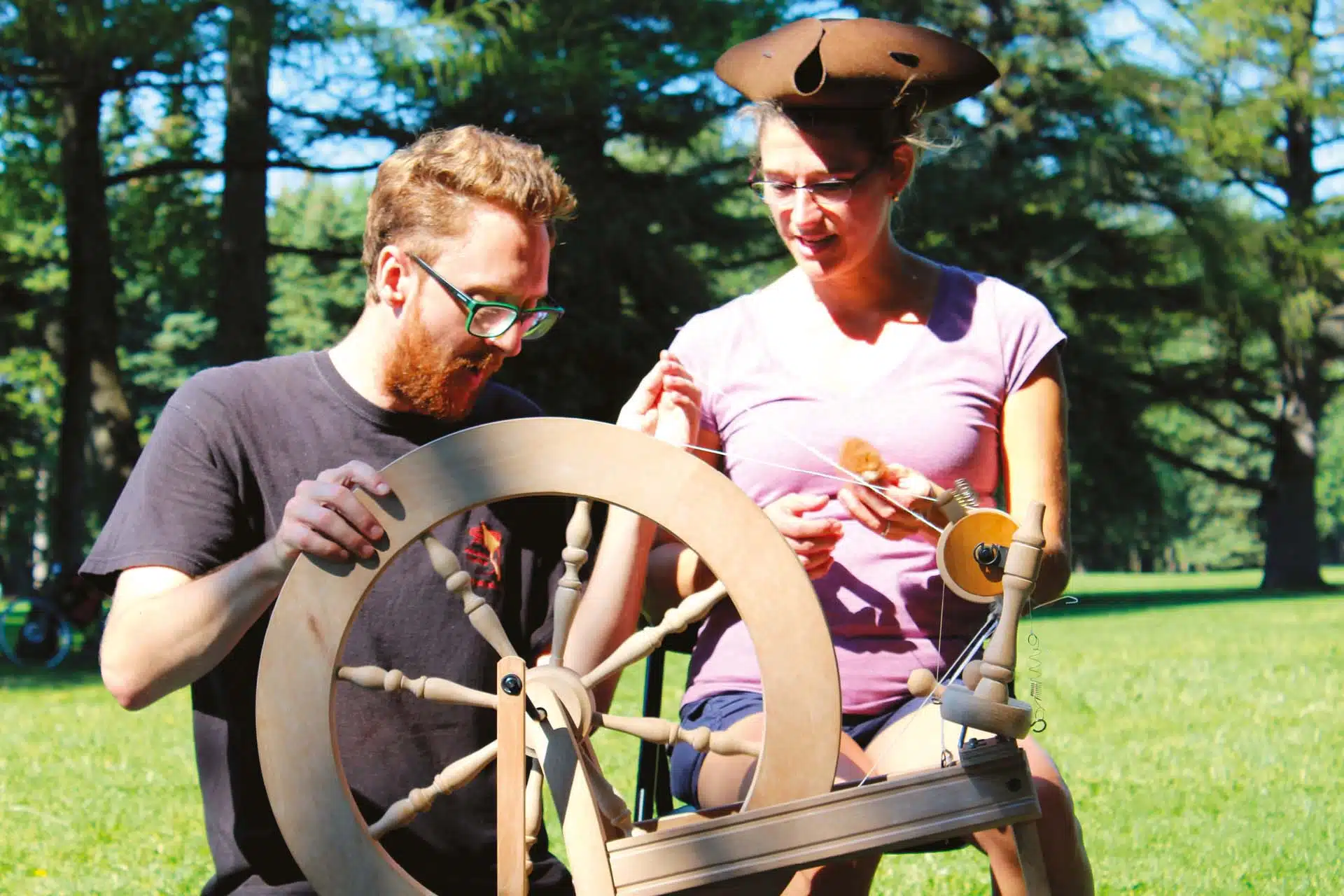 un homme et une femme manipulent un rouet
