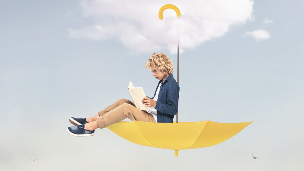 Jeune homme assis à l'intérieur d'un parapluie jaune qui est accroché à un nuage dans le ciel. Il lit un livre.